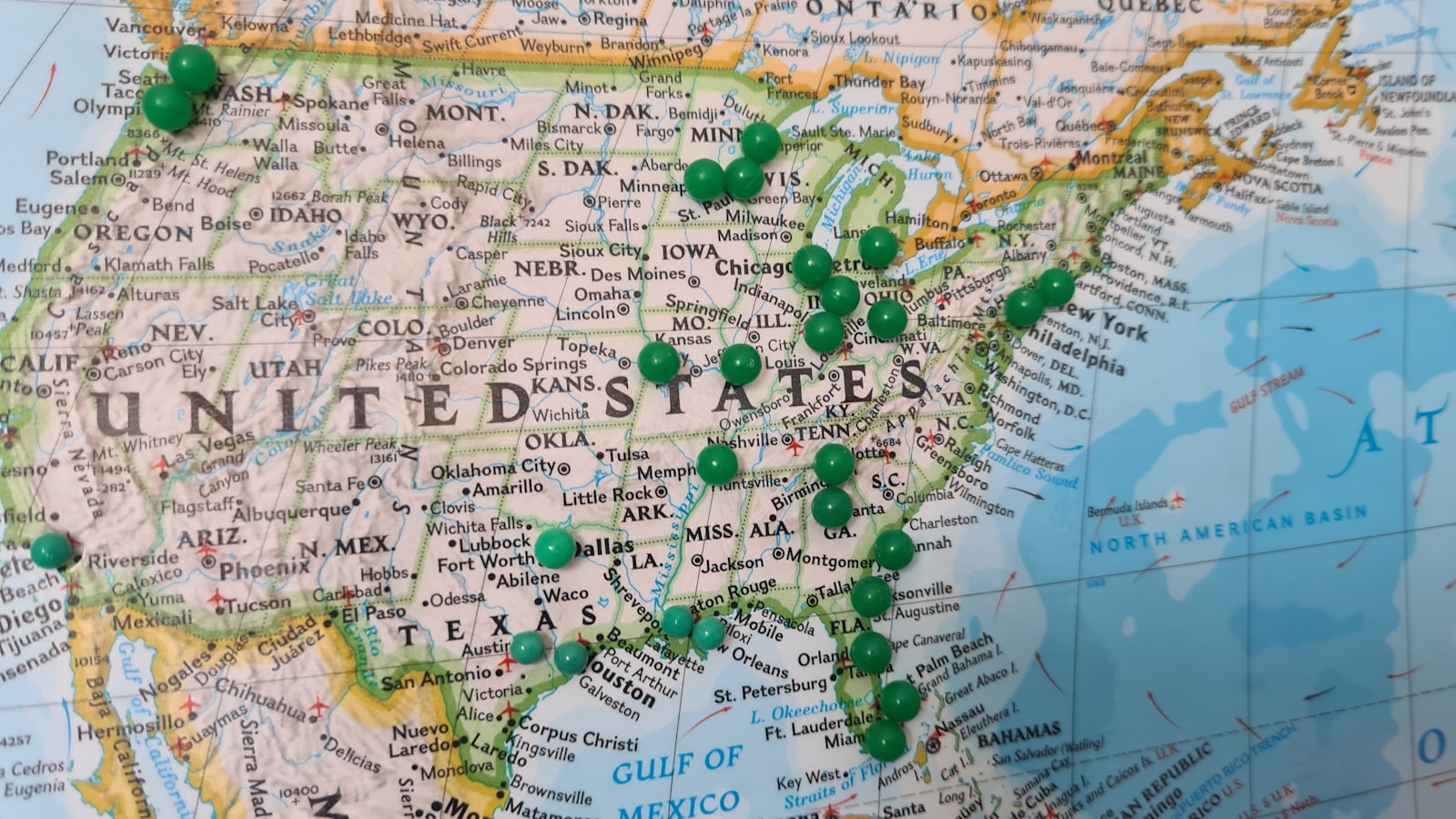 Map covered in coloured push pins marking multiple locations
